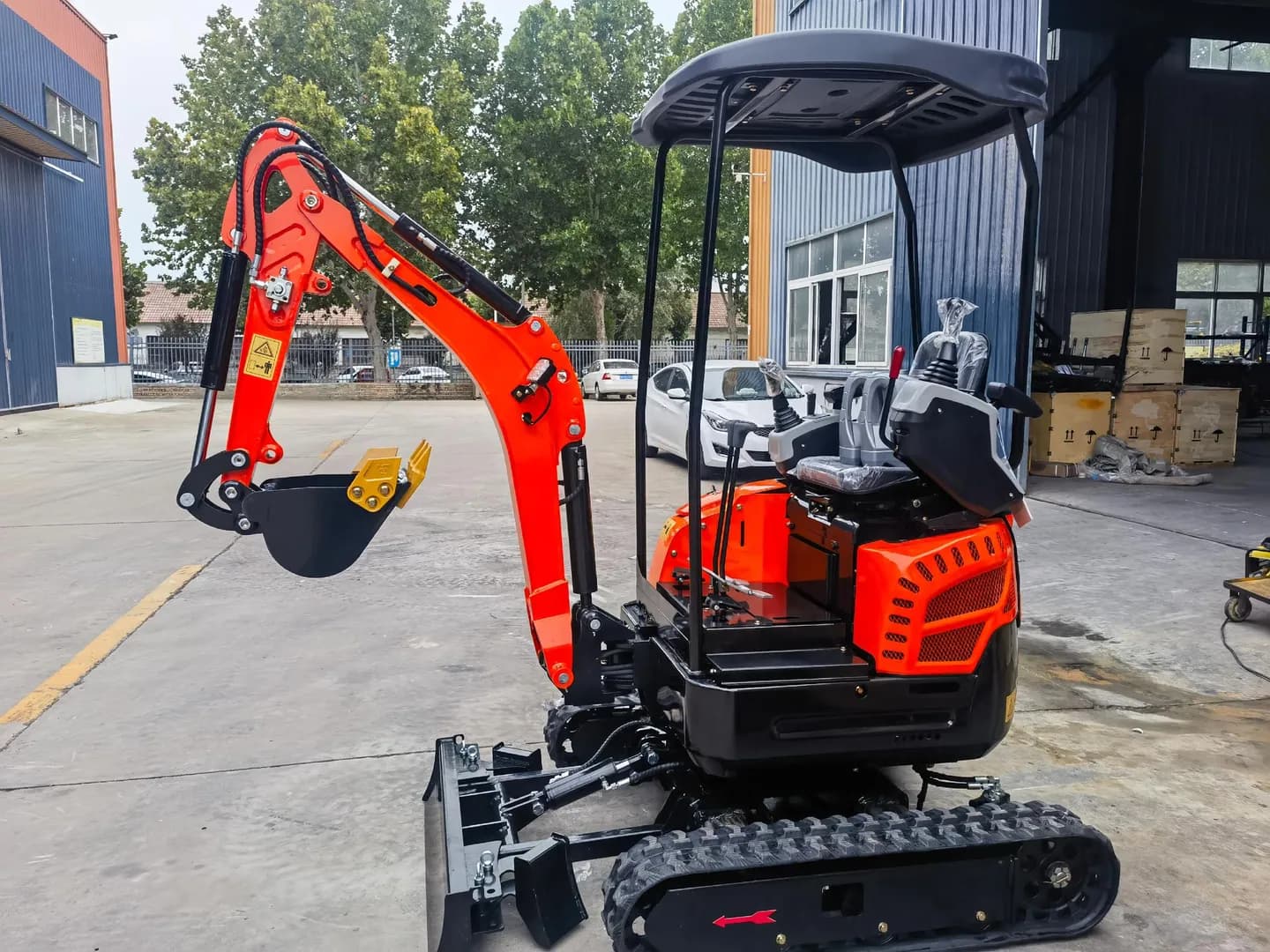 Red compact excavator with canopy and operator seat, front three-quarter view