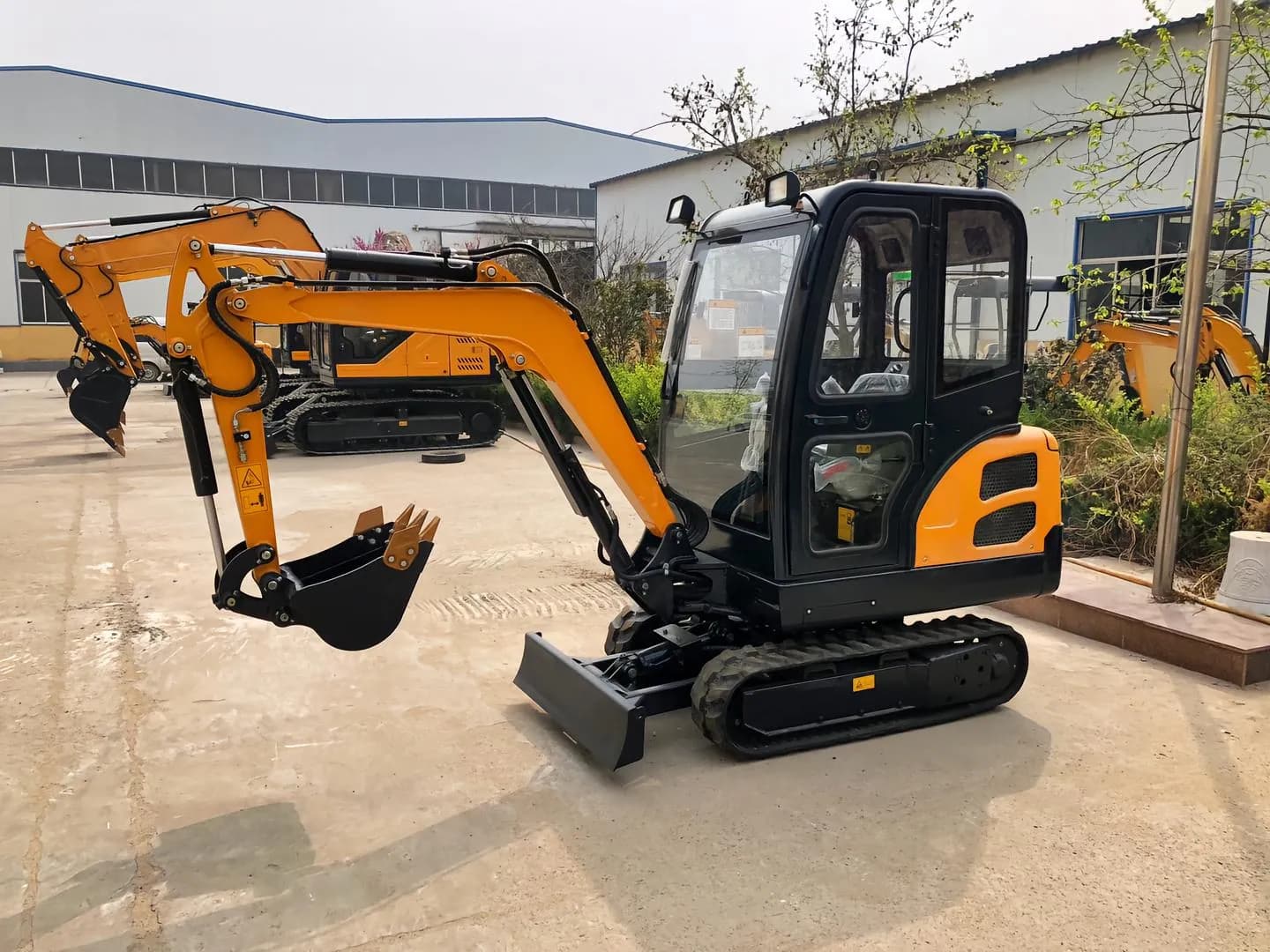 Yellow tracked excavator with enclosed cab, side-front view