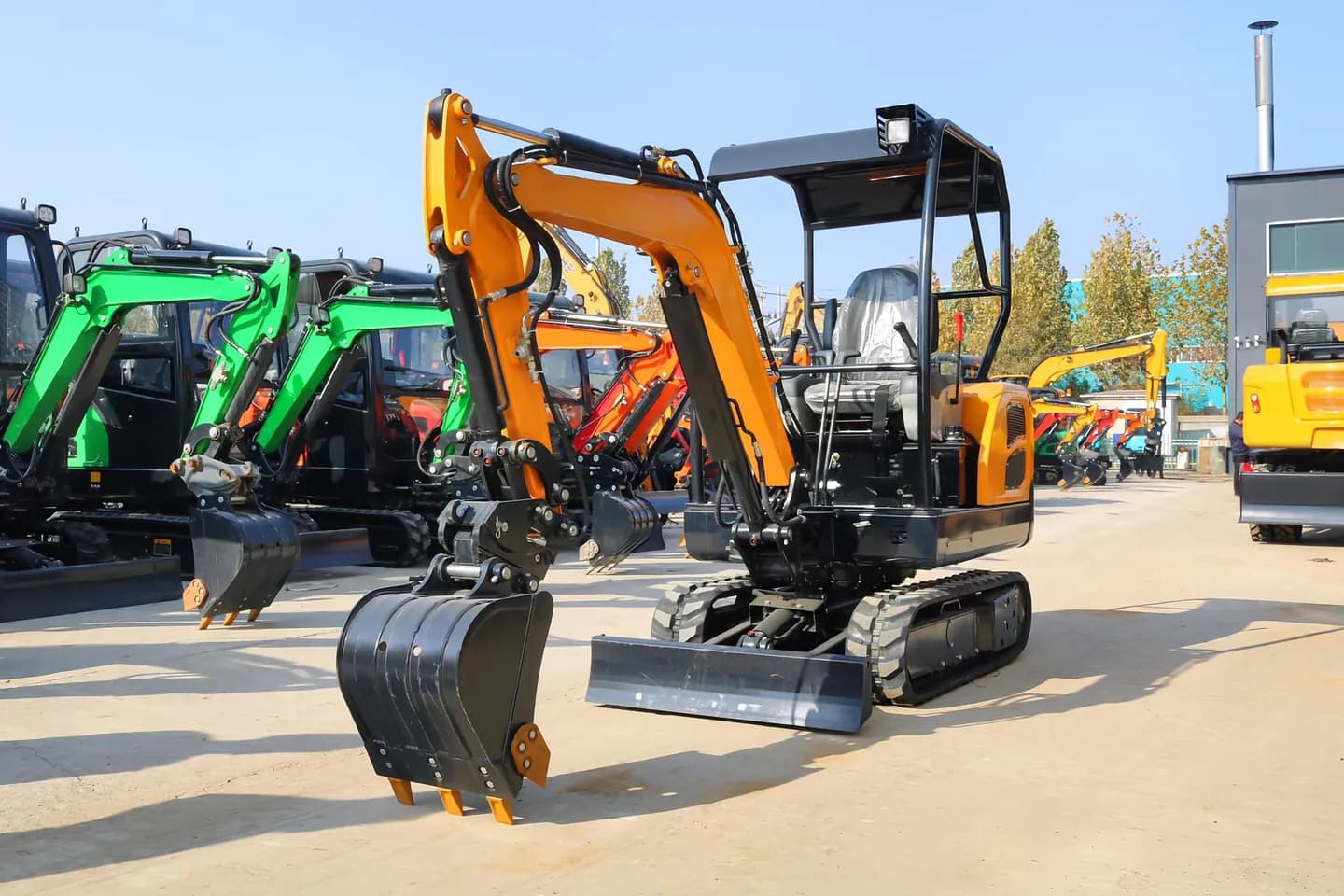 Orange canopy excavator with digging bucket, front three-quarter view