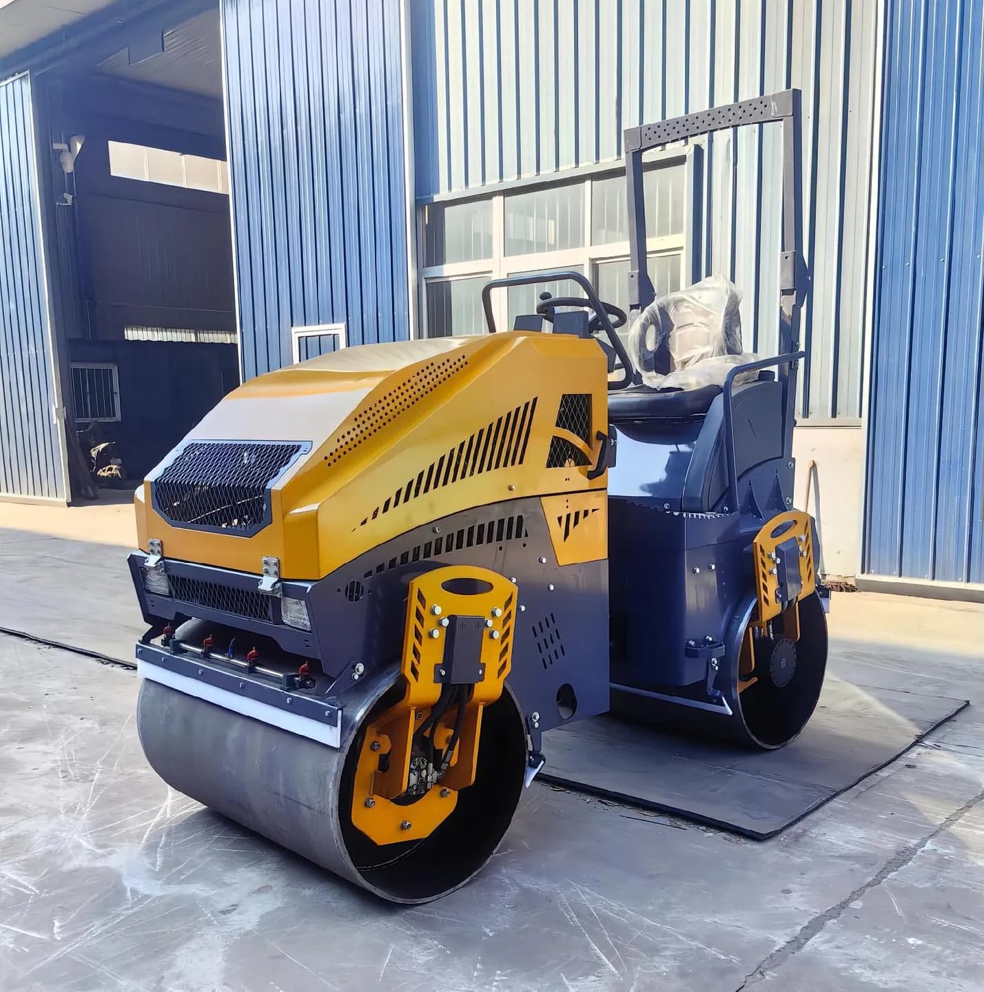 Yellow seated twin-drum roller showing its front drum and body cover