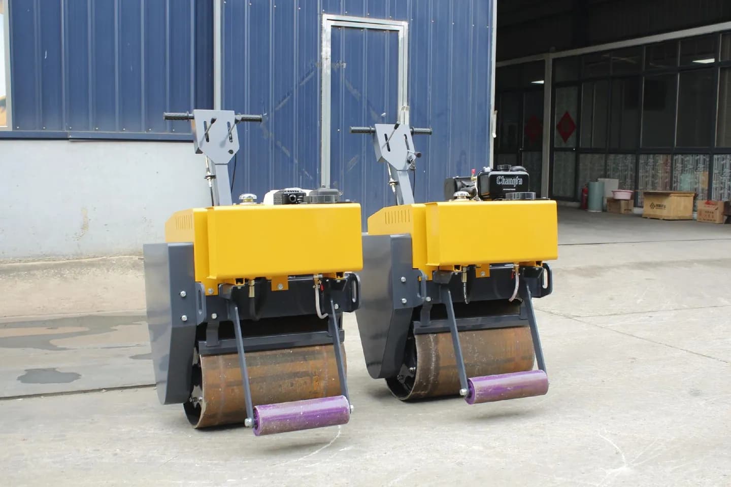 Two walk-behind single-drum rollers showing their front drums and support wheels